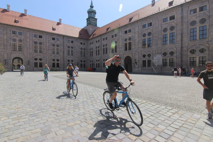 a group of people riding on the back of a bicycle