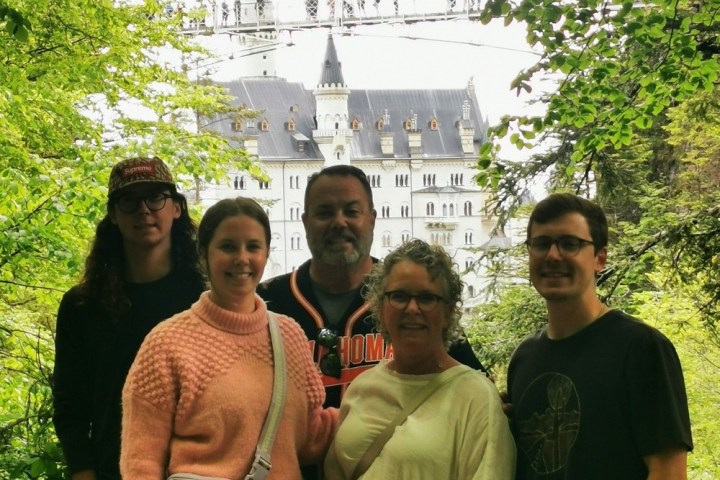 a group of people standing in front of a tree posing for the camera