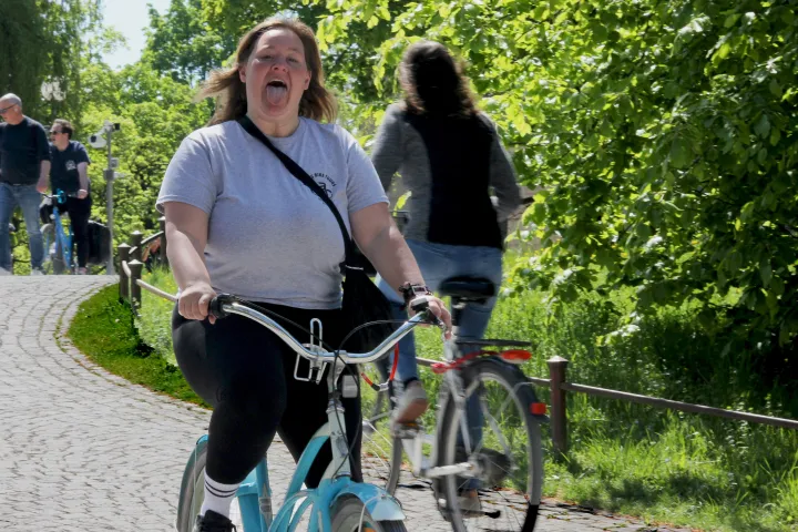 a man and a woman riding on the back of a bicycle