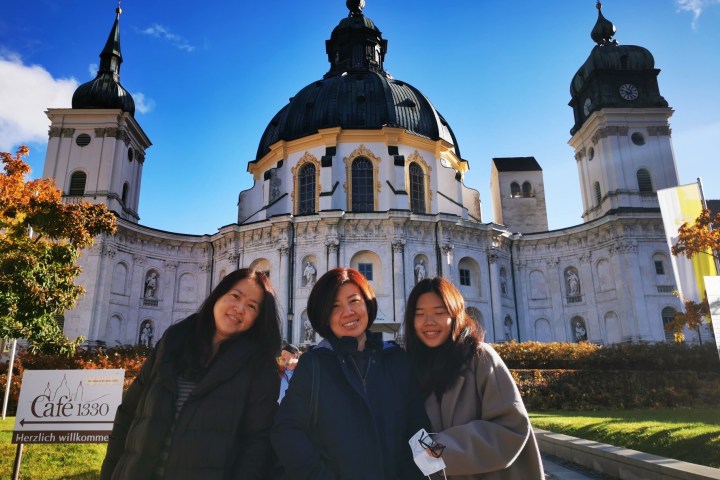 a group of people standing in front of Ettal Abbey