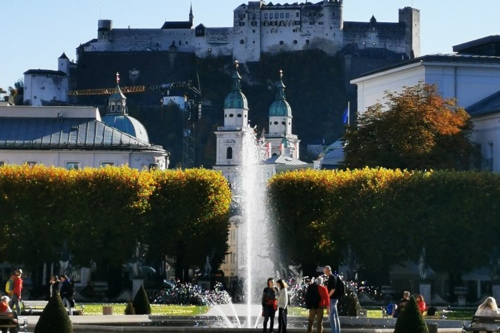 a group of people standing in front of a fountain