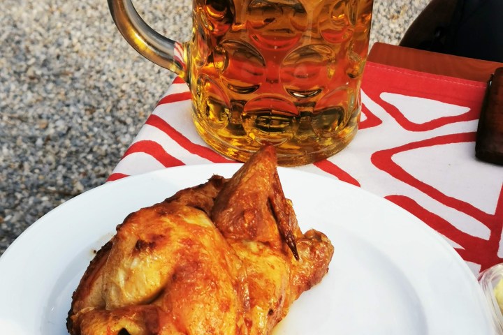 a plate of food and a glass of beer on a table