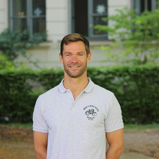 16 a man standing in front of a building